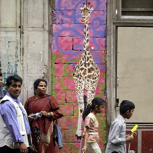 Stencil art of a giraffe graces the masonry wall of Le Temple de Ganesh in Paris